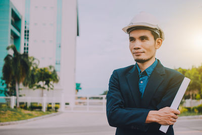 Portrait of young man standing against wall