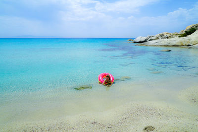 Rear view of woman in sea against sky