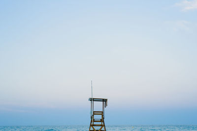 Lifeguard hut by sea against clear sky