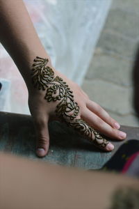 Close-up of woman with henna tattoo on hands