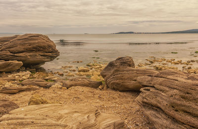 Rocks on shore against sky