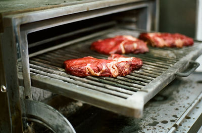 High angle view of meat on metal grate