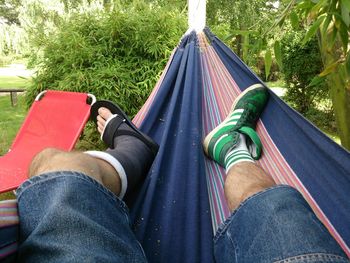 Low section of man relaxing on hammock