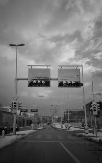 Road sign on street in city against sky