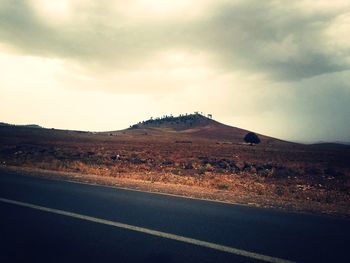 Road by mountain against sky