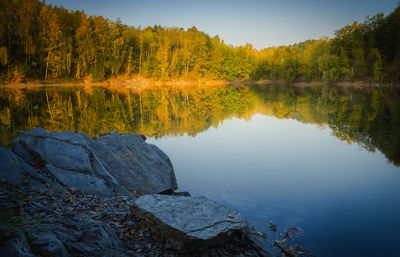 Scenic view of lake by trees against sky