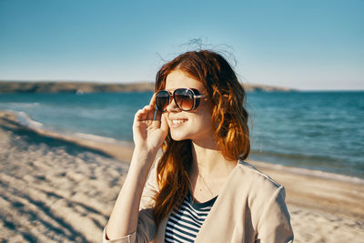 Portrait of young woman wearing sunglasses on beach