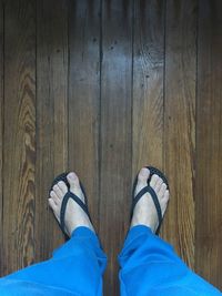 Low section of man standing on wooden floor