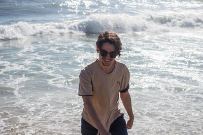 Portrait of young man standing at beach