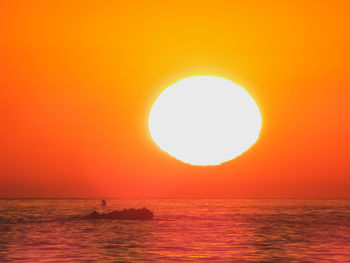 Scenic view of sea against orange sky