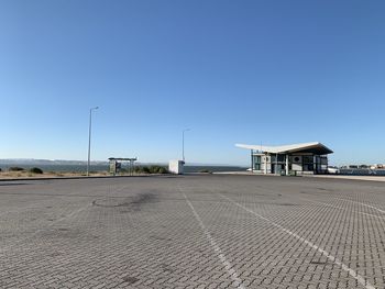 Built structure on road by building against clear blue sky