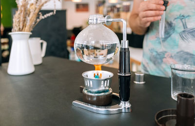 Cropped hand of person pouring coffee on table