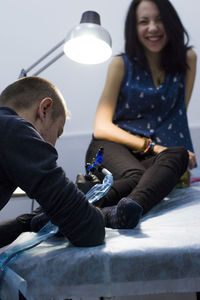 Man tattooing woman at store