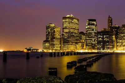 Illuminated modern buildings against sky at night