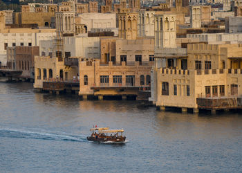 Boat in sea against buildings in city