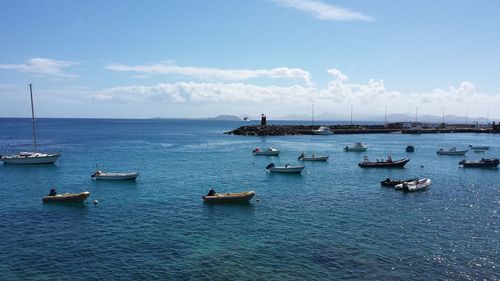 Boats sailing in sea against sky