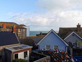 Houses by sea against sky in city