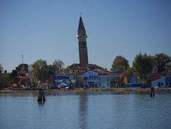 View of building by lake against sky