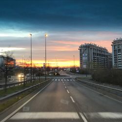 Cars on road against sky during sunset