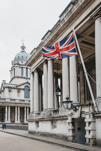 Low angle view of flags on building against sky