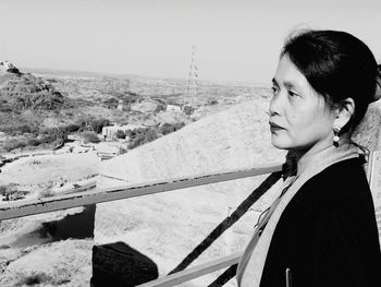 Side view of woman looking away against sky