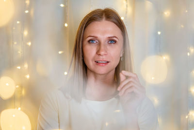 Portrait of beautiful woman with blue eyes close-up. bokeh garlands in delicate