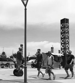 People on street against sky in city