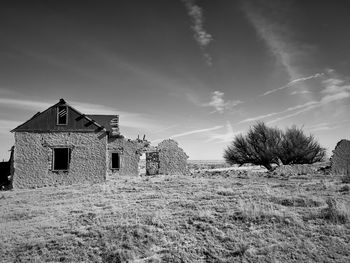 Abandoned house on field against sky