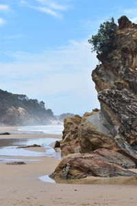 Rock formation on beach against sky