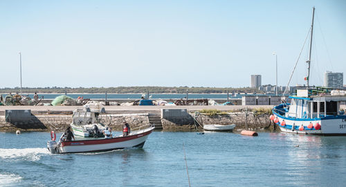 Sailboats moored on sea against clear sky