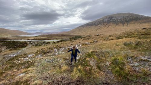 View of woman walking on mountain against sky