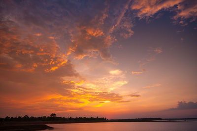 Scenic view of sea against dramatic sky during sunset