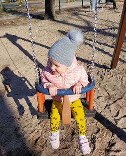 Rear view of boy swinging at playground