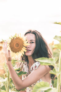 Portrait of woman holding sunflower