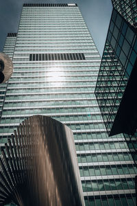 Low angle view of modern glass building against sky