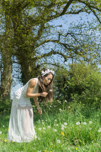 Portrait of young woman standing by plants