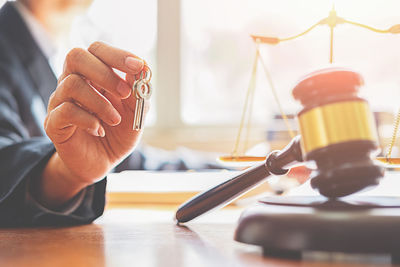 Close-up of gavel on table with female lawyer in background at office