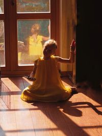 Woman sitting by window at home