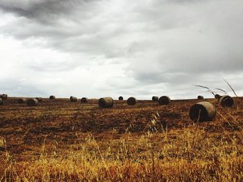 Scenic view of field against cloudy sky