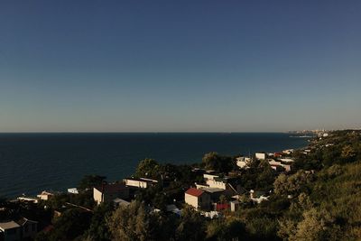 High angle view of townscape by sea against clear sky