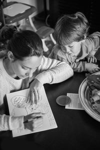 High angle view of mother and son drawing at table