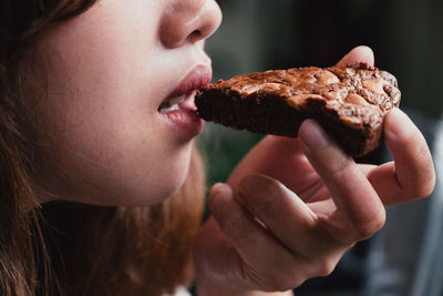 Midsection of young woman eating cake