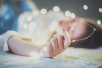 Close-up of woman hand on bed