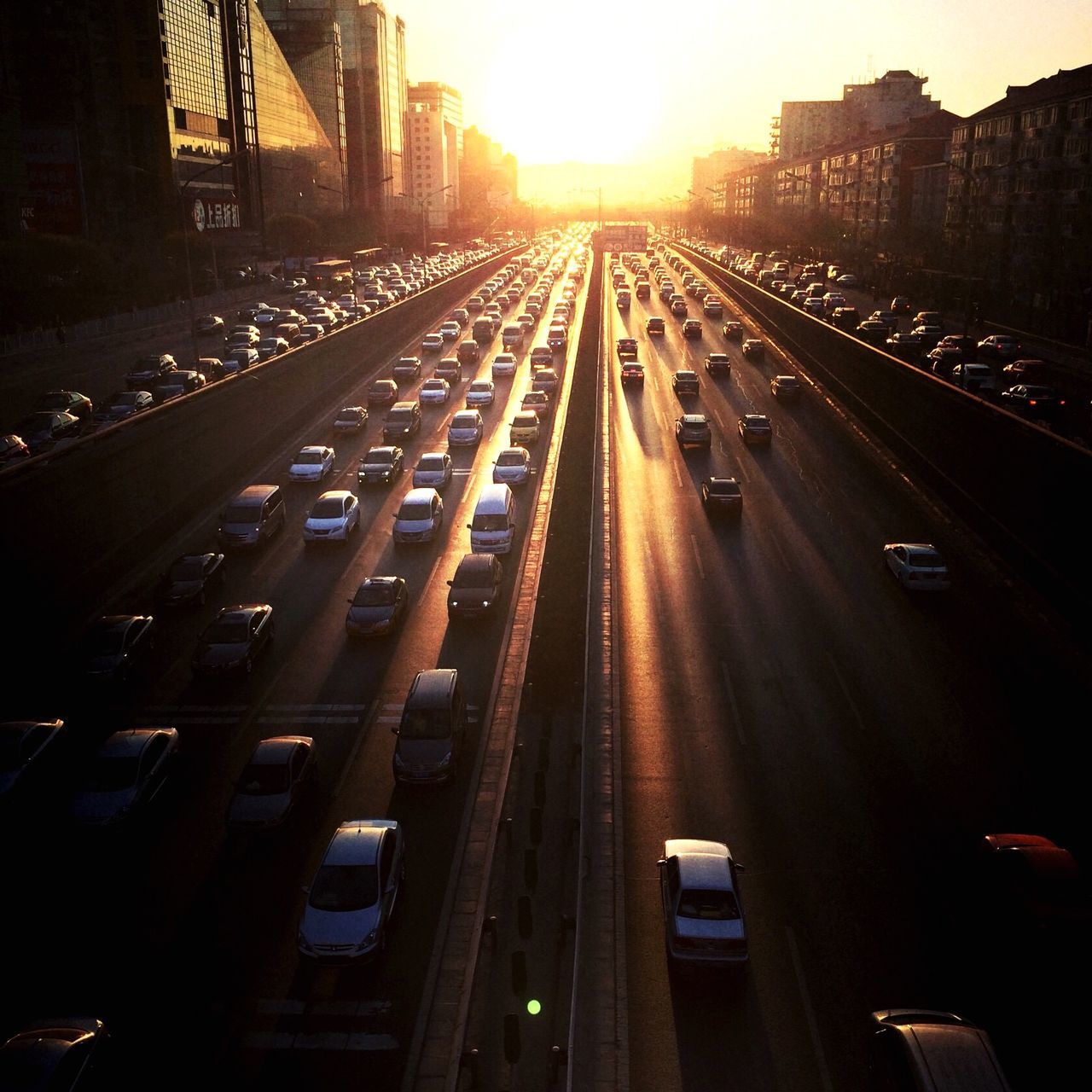 transportation, the way forward, architecture, built structure, city, diminishing perspective, vanishing point, building exterior, mode of transport, railroad track, car, land vehicle, road, high angle view, sunlight, traffic, sunset, street, road marking, city life