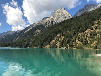 Scenic view of lake by mountains against sky