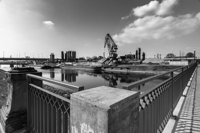 Bridge over river in city against sky