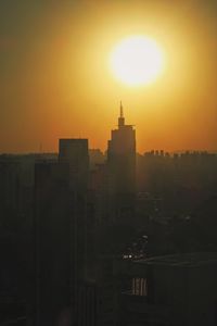 Silhouette buildings against sky during sunset
