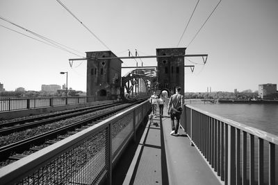 Rear view of man on railroad tracks against sky