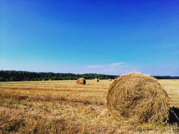 Hay bales on field against sky