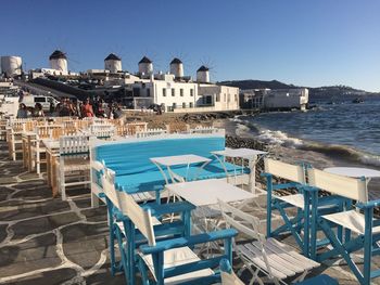 Tables and chairs arranged at promenade